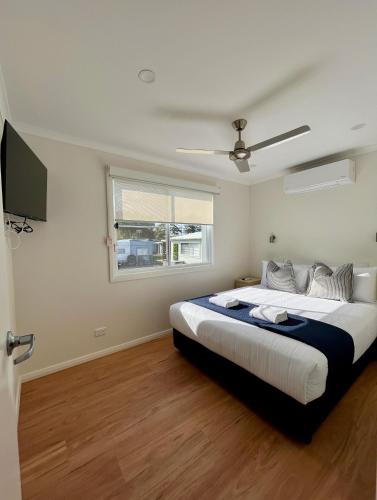 a bedroom with a large bed and a window at Shelly Beach Holiday Park in The Entrance