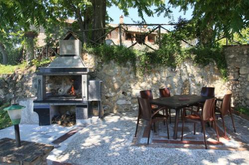 a table and chairs and a fireplace in a yard at Agriturismo Podere Luchiano in Amelia
