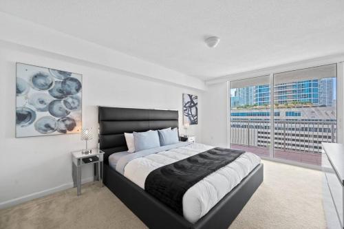 une chambre avec un grand lit et une grande fenêtre dans l'établissement Well Located Unit with parking - Heart Of Brickell, à Miami