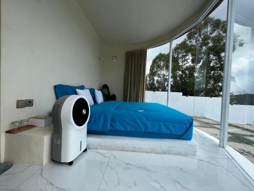 um quarto com uma cama azul e uma janela em Highland Bali em Baturaja