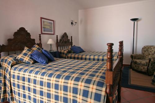 sypialnia z 2 łóżkami i krzesłem w obiekcie Alojamento Pero Rodrigues w mieście Alandroal