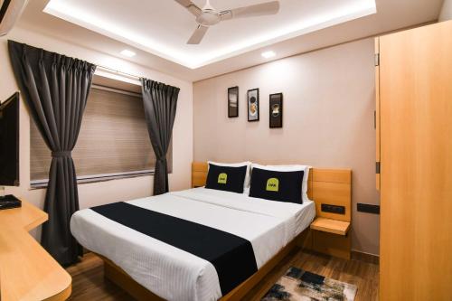 - une chambre avec un lit et des oreillers noirs et blancs dans l'établissement Townhouse OAK Sayhallo Ecstasy, à Bhubaneswar