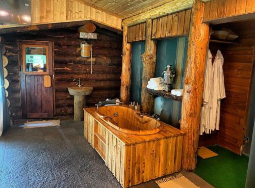 baño de madera con bañera de madera y lavamanos en Forest Houses,Форест Хаусис, en Godech