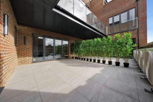 OYO Fine B&B في Hanwell: مبنى من الطوب مع ساحة مع نباتات الفخار