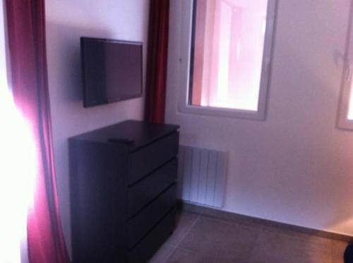 a room with a dresser with a television on it at Ferme Sainte Marie in Rémilly
