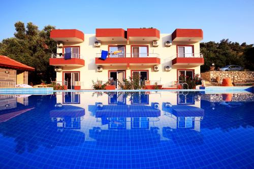 a hotel with a swimming pool in front of a building at Rose Pension in Patara