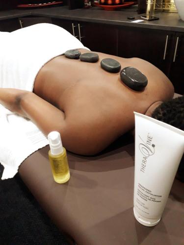 a naked woman laying on a bed with a bottle of oil at Garden Top Hotel in Johannesburg
