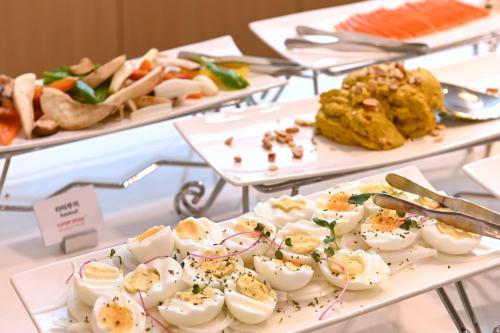 un buffet de alimentos con huevos revueltos y otros alimentos en Coopstay Yeosu Hotel, en Yeosu