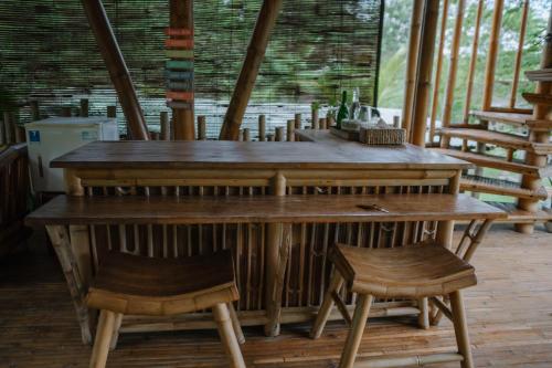 a wooden table and two stools in a room at Sun Sang Eco Retreats in Tabanan