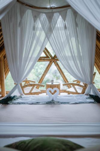 a bedroom with a bed with two hearts on it at Sun Sang Eco Retreats in Tabanan