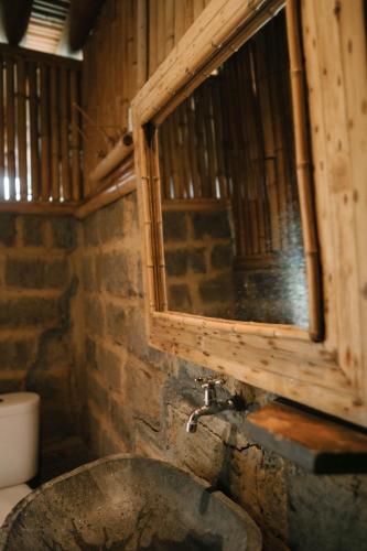 a bathroom with a stone sink and a window at Sun Sang Eco Retreats in Tabanan