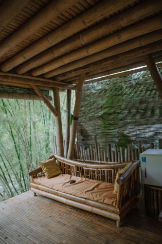 a wooden bed on a deck in a pavilion at Sun Sang Eco Retreats in Tabanan