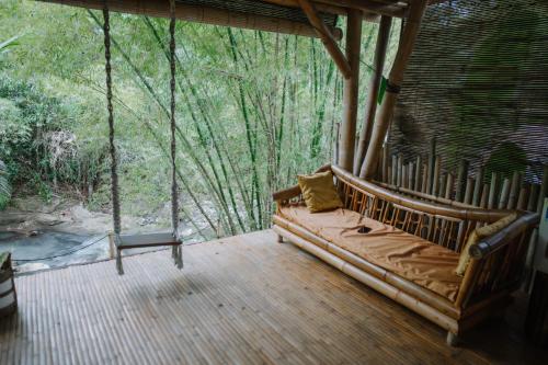 a living room with a couch on a porch at Sun Sang Eco Retreats in Tabanan