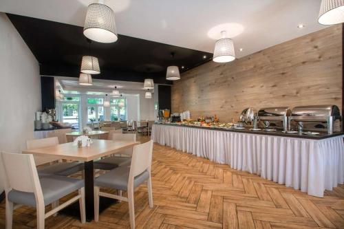 Un restaurante con una mesa y sillas y un bar. en Resort Moderna Jastrzębia Góra, en Jastrzębia Góra