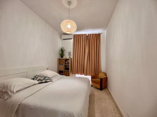 une chambre avec un lit blanc et une fenêtre dans l'établissement Centre heart of CAnnes, à Cannes