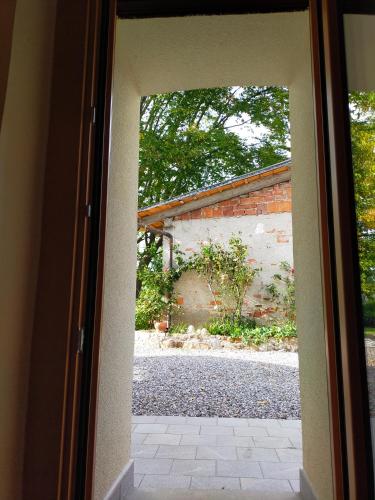 an open door to a yard with a brick building at Le camere dell'Albero Bianco con uso cucina in Manzano