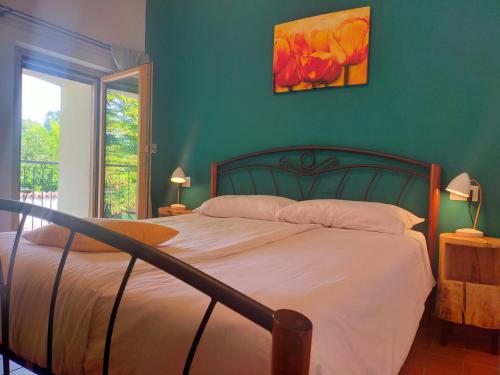 a bedroom with a bed with a green wall at Le camere dell'Albero Bianco con uso cucina in Manzano