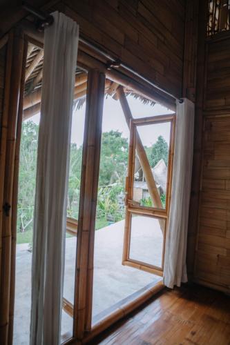 an open window with a view of a yard at Sun Sang Eco Retreats in Tabanan