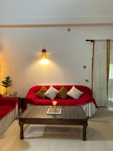 a living room with a red couch and a table at One Bhakthi in Ahangama
