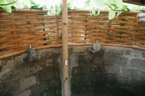a wooden fence with vases on a brick wall at Sun Sang Eco Retreats in Tabanan