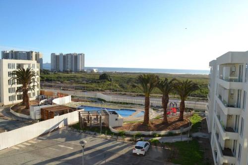 uitzicht op een zwembad met palmbomen en een gebouw bij Duplex 2D 2B con vista al mar in La Serena
