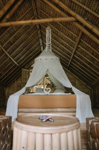a canopy over a bed in a room at Sun Sang Eco Retreats in Tabanan