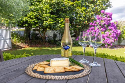 a plate of cheese and crackers and a bottle of wine at 2 Bedroom Home away from Home near CBD & private parking in Hamilton
