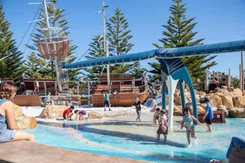 a group of people playing in the water at a water park at API Busselton Seaside Escape Apartments in Busselton