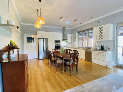 a kitchen and dining room with a table and chairs at The Gabby's Holiday House in Nuriootpa