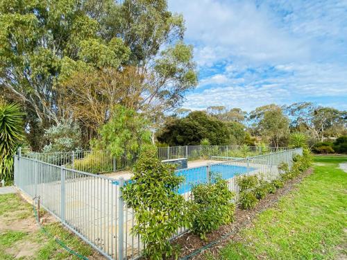 a fence around a swimming pool in a yard at The Gabby's Holiday House in Nuriootpa