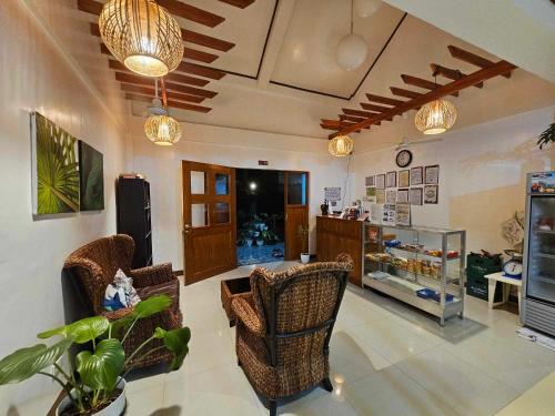 a living room with chairs and a table and a store at Bella Vita Guest House in Coron