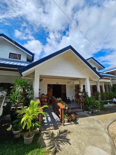 a white house with plants in front of it at Bella Vita Guest House in Coron