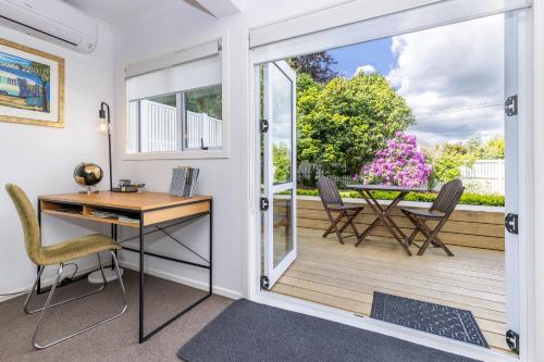 a home office with a desk and a sliding glass door at 2 Bedroom Home away from Home near CBD & private parking in Hamilton