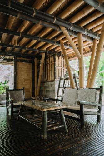 two chairs and a coffee table in a room at Sun Sang Eco Retreats in Tabanan