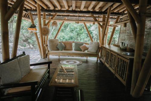 a living room with a couch and a table at Sun Sang Eco Retreats in Tabanan