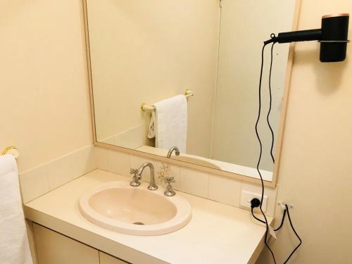 a bathroom with a sink and a mirror at API Preston Beach Front Apartments in Preston Beach