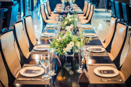a long table with glasses and flowers on it at Holiday Inn Beijing Focus Square by IHG in Beijing