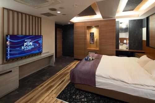 a hotel room with a bed and a television at ホテル ブルジュア 久留米 Hotel Bvljua -レジャーホテル- in Kurume
