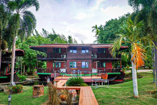 a house on a boat in a yard with palm trees at Kaengkrachan Boathouse Paradise Resort in Kaeng Krachan