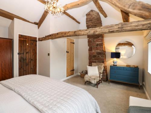 a bedroom with a white bed and a blue dresser at Croft Cottage in Long Marton