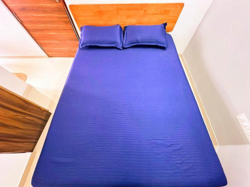 Bett mit blauen Kissen in einem Zimmer in der Unterkunft Compact yet beautiful 1bhk 201 in Bangalore