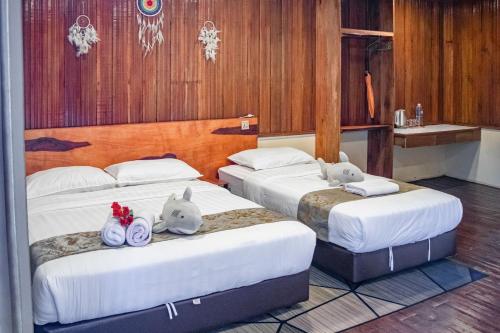 two beds with stuffed animals on them in a room at Timba Garden FREE TOWN AND JETTY TRANSPORT in Semporna