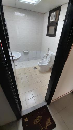 y baño con aseo y lavamanos. en Adbldna01, en Abu Dabi