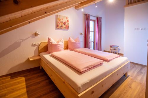 ein Schlafzimmer mit einem großen Bett mit weißer Bettwäsche in der Unterkunft Ferienwohnungen zum Nigglhof in Wackersberg
