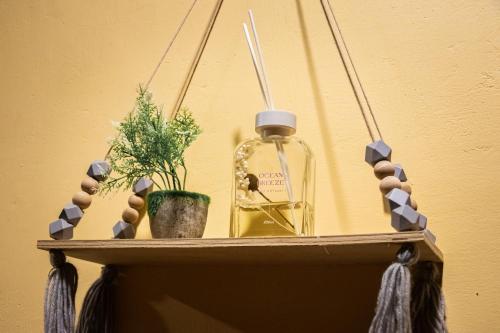 a shelf with a bottle and a plant on it at Timba Garden FREE TOWN AND JETTY TRANSPORT in Semporna