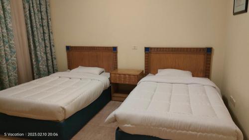 2 łóżka w małym pokoju z: w obiekcie Naama Bay, 2BR Pool and sea view, Center Naama Bay Sharm El-Sheikh w Szarm el-Szejk