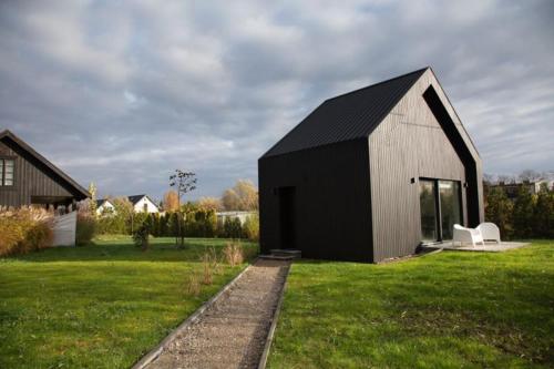 a black and white house with a white chair in a yard at Green corner in Krakow