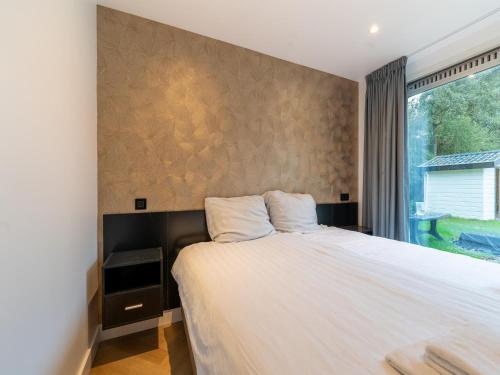 - une chambre avec un grand lit et une fenêtre dans l'établissement Cozy holiday home in South Holland in a wonderful environment, à Zevenhuizen