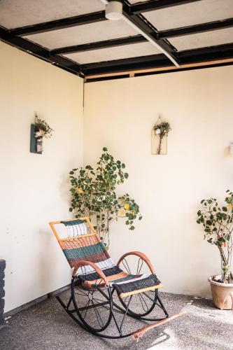 a rocking chair in front of a white wall with potted plants at Timba Garden FREE TOWN AND JETTY TRANSPORT in Semporna