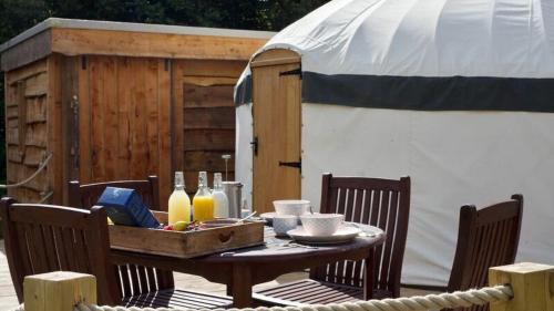 un tavolo in legno con un vassoio di cibo sopra di Bracken Yurt at Walnut Farm Glamping a Netherbury
